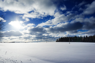 Winter landscape with snow covered countryside. European winter landscape. Blue sky, bright sun and white snow.