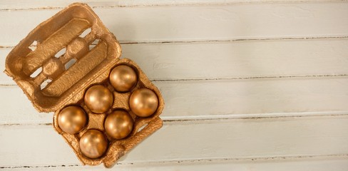 Golden Easter eggs in carton