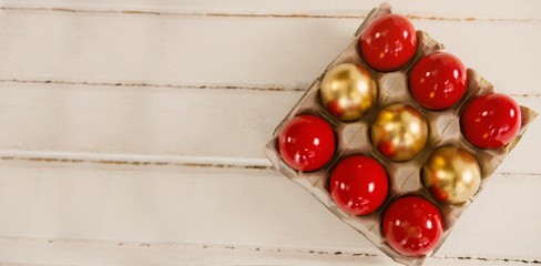 Red and golden Easter eggs in carton