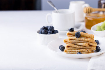 Breakfast with thin pancakes (crepes), blueberries and coffee