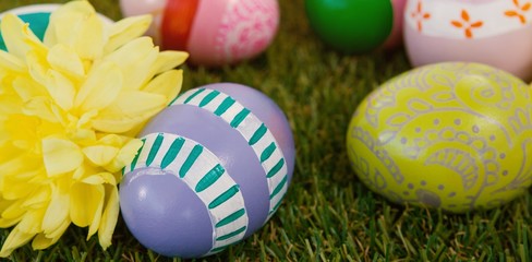 Obraz na płótnie Canvas Painted easter eggs with flowers on grass