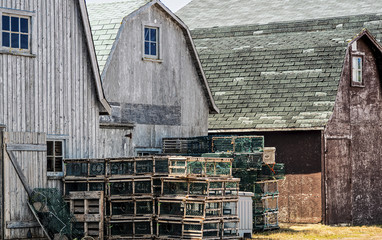 Lobster traps stacked outside fishing shacks
