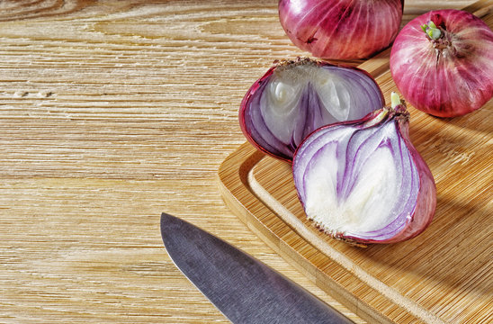 Tubers of red onions, on a wooden background