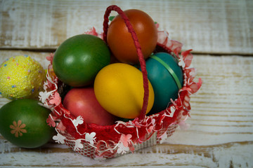 Easter painted eggs in a bowl on a wooden background