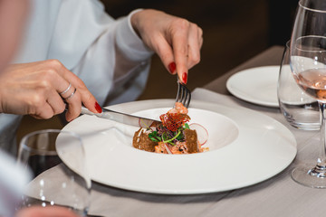 woman is preparing to eat delicious salmon salad in a restaurant. small portion