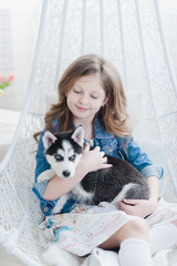 little girl hugging a puppy Husky