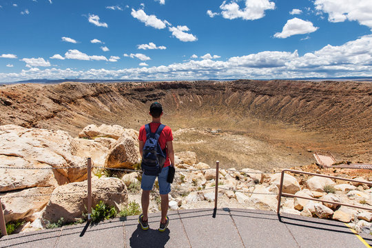 Travel in Meteor Crater, man hiker with backpack enjoying view, Winslow, Arizona, USA