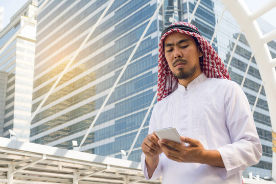 Arab businessman messaging on a mobile phone in the city