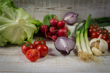 Fresh seasonal vegetables on the white wooden background