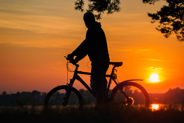 Obraz premium Single bicycle standing on a sunset under trees. Cyclist at sunset