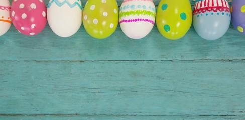 Various Easter eggs arranged on wooden surface