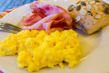 Scrambled eggs with bacon and bread with seeds