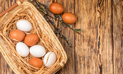 White and brown eggs in the basket on the table. Easter
