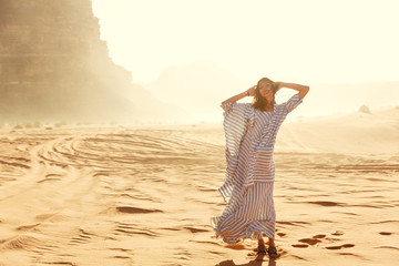 Stylish girl in white dress in Wadi Rum desert in Jordan