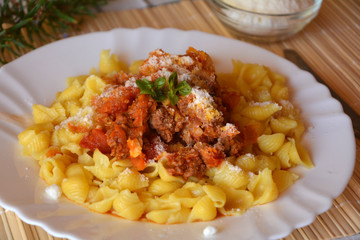 Pasta bolognese with meat and tomato sauce and parmesan on a plate.