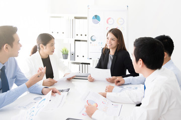 Asian business team discussing work at meeting table
