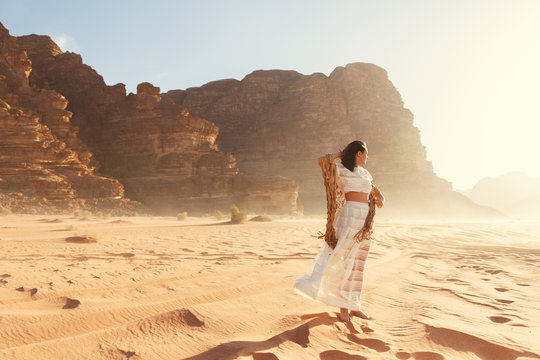 Stylish girl in white dress in Wadi Rum desert in Jordan