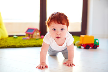 cute toddler baby crawling on the floor at home