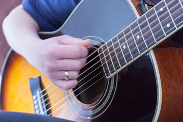 hand playing on an acoustic guitar