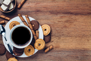 black coffee in white cup with cookie and dessert