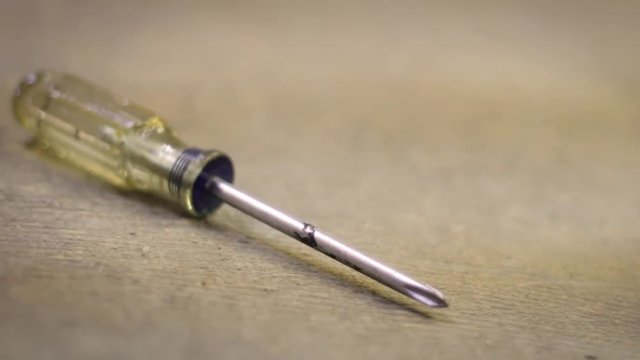 A used screwdriver sitting on the floor of a work room