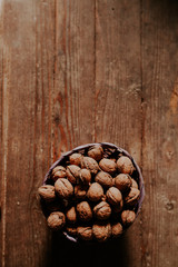 Whole walnuts on rustic old wooden floor, shot in natural light. Concept of healthy organic food.