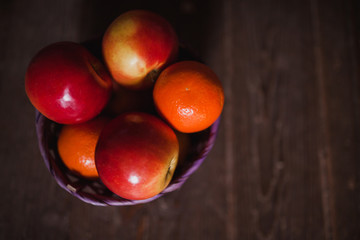 Apples and oranges on old wooden background. Bio food concept.