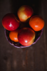 Apples and oranges on old wooden background. Bio food concept.