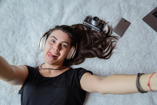 woman taking selfie in bed, music