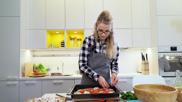 female chef preparing pizza in a kitchen