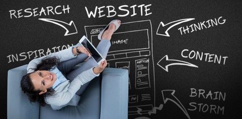 Composite image of woman on her tablet looking up