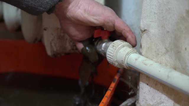 Replacing of iron hot water radiator by a plumber. Draining down the central heating system in a home.