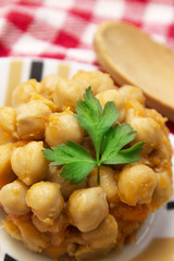 Cooked chickpeas on wooden background and red tablecloth