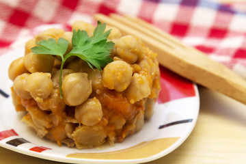 Cooked chickpeas on wooden background and red tablecloth