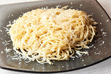 Spaghetti with grated cheese on a plate. Close up.
