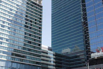 Cityscape view with business buildings with contemporary architecture in metropolitan city in day. High-rise modern skyscrapers in big town against grey sky