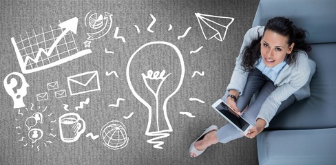 Composite image of woman on her tablet looking up