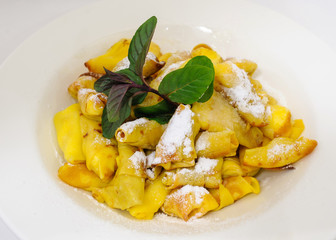 Stack of delicious pancakes with powdered sugar on plate