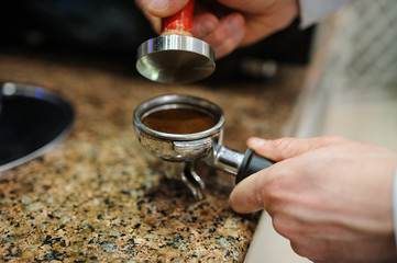 Closeup barista grinding fresh coffee