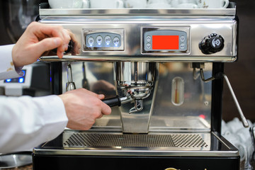 Closeup of a man barista brewing an espresso using a coffee machine