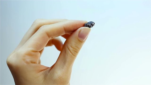 Meteorite Piece (meteor)- debris from space. Hand Holding Piece of Meteorite.