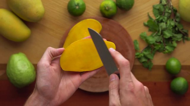Man cuts a mango on peaces. Process of making a Juicy mango shake. Healthy life concept