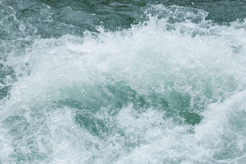 Fototapeta na wymiar splashes of mountain river waves close up. Churning blue water in the ocean shows lots of turbulence and splash. freshness concept. elements of water.