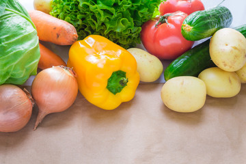 fresh vegetables. Tomatoes, potatoes, cucumber, peppers, onions, lettuce, carrots, cabbage on a table with paper
