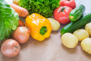 fresh vegetables. Tomatoes, potatoes, cucumber, peppers, onions, lettuce, carrots, cabbage on a table with paper