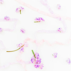 Pattern of pink hyacinth flowers and shabby tapes on white background. Flat lay, top view
