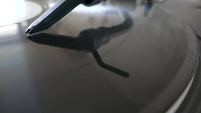 Low angle footage of a turning vinyl and a spherical needle on it...