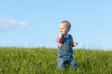 Cute baby girl walking on green grass
