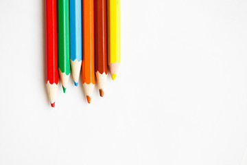 Multicolored pencils lying on a white table
