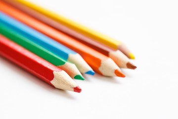 Multicolored pencils lying on a white table